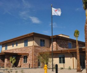 brown building with a flagpole in the front